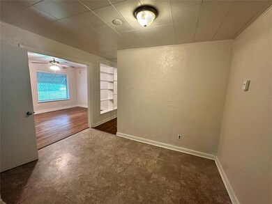 Spare room with a textured wall, baseboards, and built in shelves