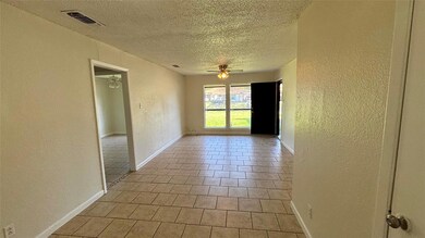 Empty room featuring a textured wall, visible ven