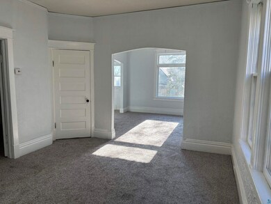 Spare room with dark colored carpet and crown mold