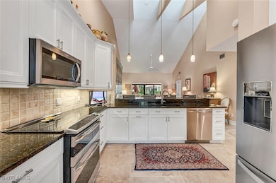 Kitchen featuring dark stone counters, appliances