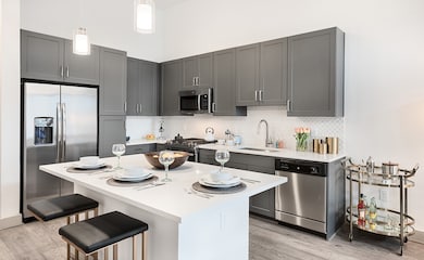 Model has a has abundant cabinet space ,side by side refrigerator,  a dining island which frees up space in the living area with pendant lighting