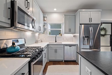 Kitchen with recessed lighting, a sink, dark wood