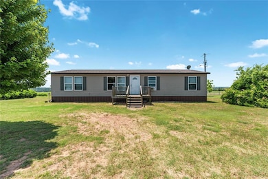 Manufactured / mobile home featuring a front lawn and a wooden deck