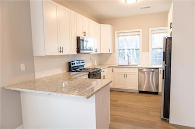 Kitchen with visible vents, a peninsula, stainless