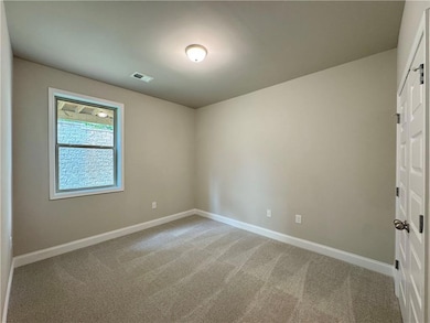 Spare room with baseboards and light carpet
