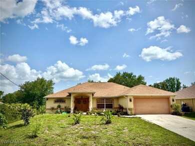 View of front of house with stucco siding, drivewa