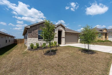 View of front of house with stone siding, concrete driveway, and a garage