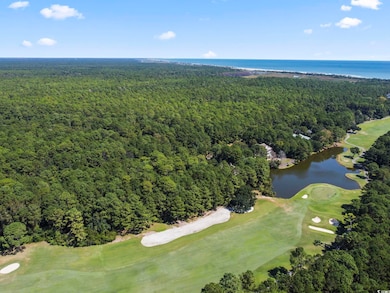 Aerial view of property and surrounding area with a nearby body of water and a golf course