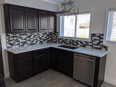 Updated kitchen has new cabinets, glass tile back 