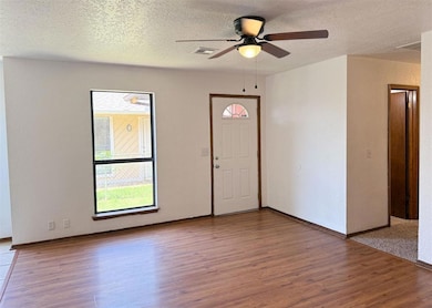 Foyer featuring wood finished floors, a textured ceiling, and a ceiling fan