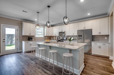 Kitchen featuring crown molding, stainless steel a