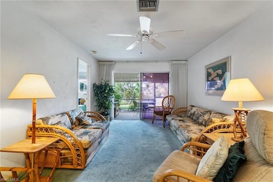 Carpeted living room with ceiling fan