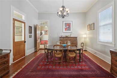 Spacious dining room has wood floors and crown mol