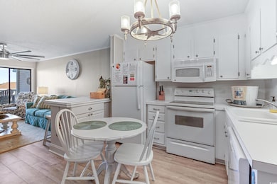 Kitchen featuring white cabinets, white appliances