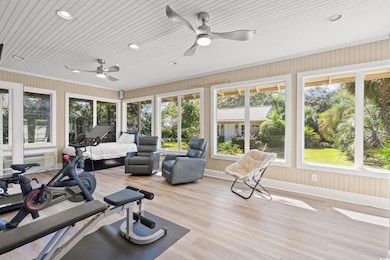 Workout room featuring light wood-style flooring, recessed lighting, and a ceiling fan