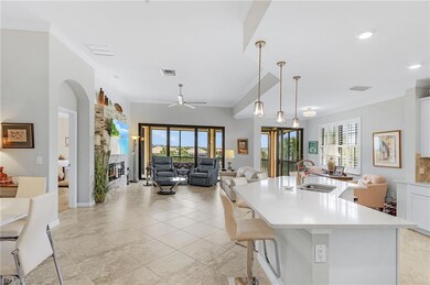 Kitchen featuring a sink, ornamental molding, plenty of natural light, light countertops, and a glass covered fireplace