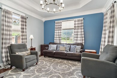 Living room with crown molding, an inviting chande