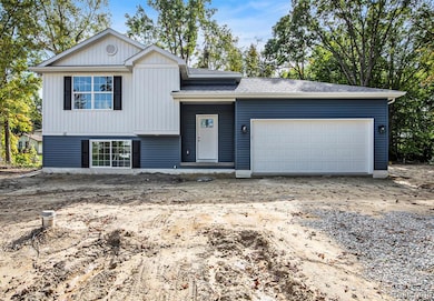 Split level home featuring driveway, a garage, and roof with shingles