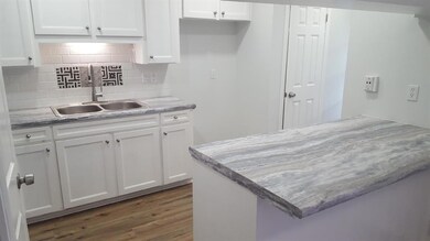 Kitchen has stainless steel double sinks and a bre