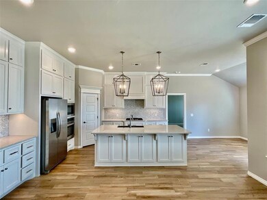 Kitchen with pendant lighting, an island with sink
