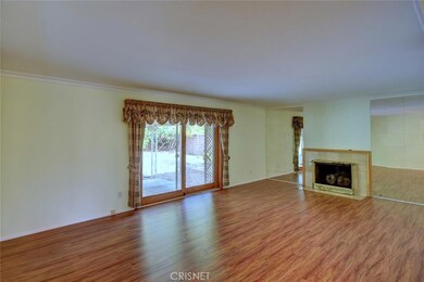 Large living room warmed by the fireplace, custom sliding glass doors with wood trim overlook back yard