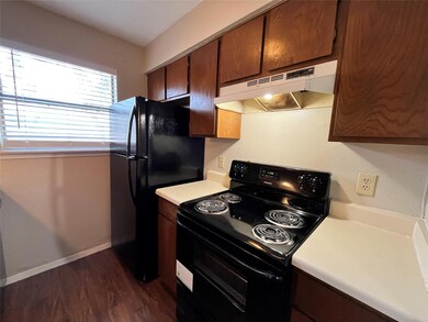 This view of the kitchen shows the black appliances and all of the cabinets.