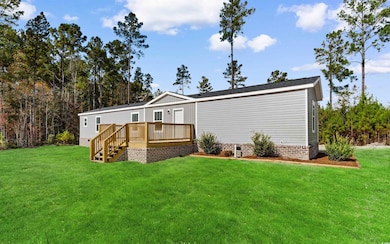 Rear view of property with a lawn, a deck, and crawl space