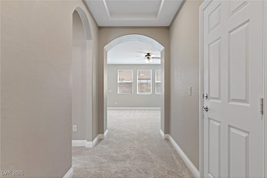 Hallway featuring carpet, arched walkways, and bas