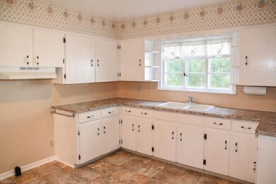 The kitchen has white cabinets and new countertops