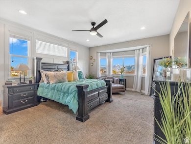 Carpeted bedroom with ceiling fan and recessed lighting
