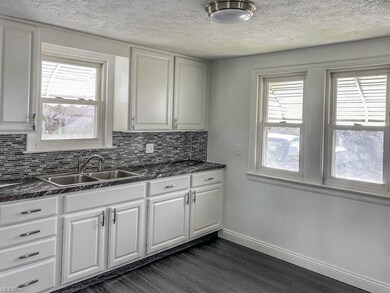 The kitchen has white cabinets and new countertops