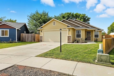 Ranch-style home featuring driveway, a garage, stone siding, and roof with shingles