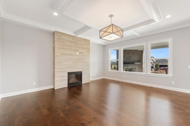 Large Family Room with trim detail on ceiling, modern tile fireplace, hardwood floors, & large windows!