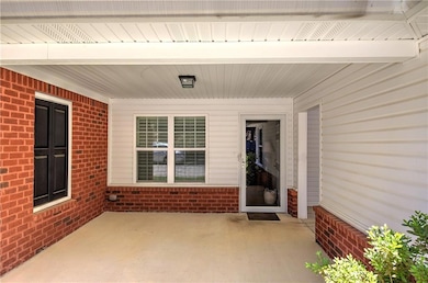 Property entrance with brick siding and a patio area