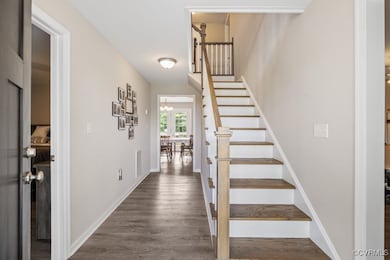 Foyer with stairs, dark wood-type flooring, a chan