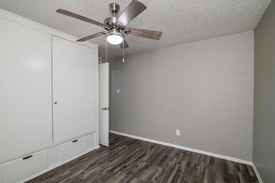 Unfurnished bedroom featuring dark wood-style floo