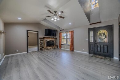 Unfurnished living room with lofted ceiling, light wood-style floors, ceiling fan, and a fireplace