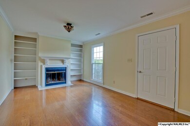 boasts wood floors, crown molding, built in book cases and a very decorative wood burning fireplace.