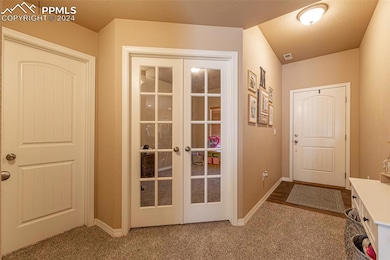 Doorway featuring french doors and carpet floors