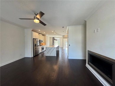 Unfurnished living room with crown molding, a fireplace, dark wood-type flooring, a ceiling fan, and recessed lighting