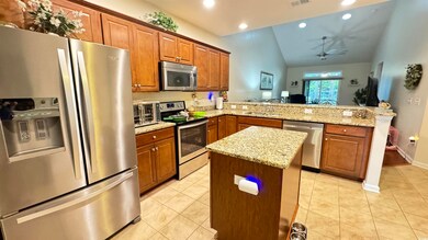 Kitchen featuring ceiling fan, a kitchen island, v