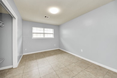 Bedroom 1 offers tile flooring, window blinds, and