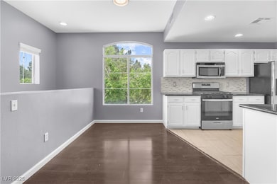 Kitchen with stainless steel appliances, dark coun