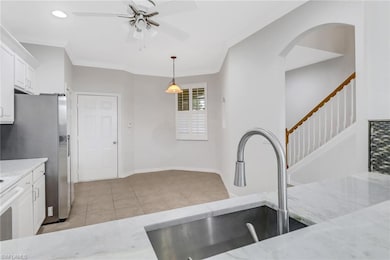 Kitchen featuring ornamental molding, white cabine