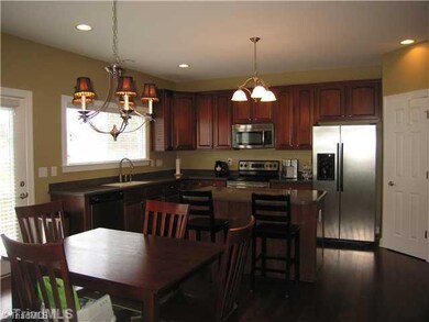 Kitchen. The kitchen is beautiful and open with solid surface counters and cherry cabinets! Kitchen island gives more food prepping space and extra seating! Built-in microwave, dishwasher, and oven/range included!