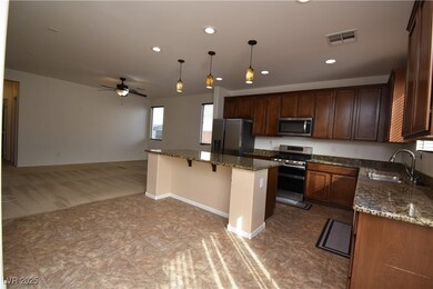 Kitchen featuring a sink, dark stone counters, hanging light fixtures, and stainless steel appliances