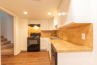 Kitchen with light wood-type flooring, white cabi