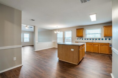 Large kitchen island with electricity, large dining area, lots of counter top space and plenty of cabinet storage.