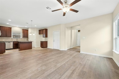 Unfurnished living room featuring a ceiling fan, 