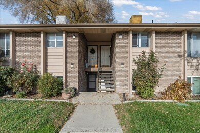 View of exterior entry featuring brick siding and a yard